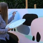 Melton artist Lisa Fitzpatrick working on her painting, Nature’s Beauty, as part of the NWMPHN Art Bomb mental health project.