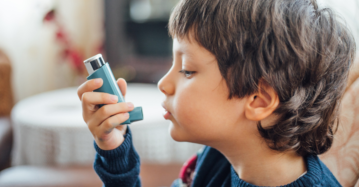 Child (boy) using asthma inhaler.