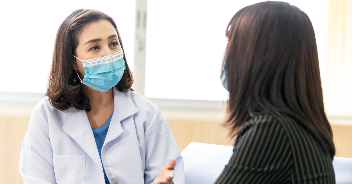 Doctor with face mask talking to patient
