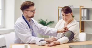 Male doctor checks blood pressure of female patient