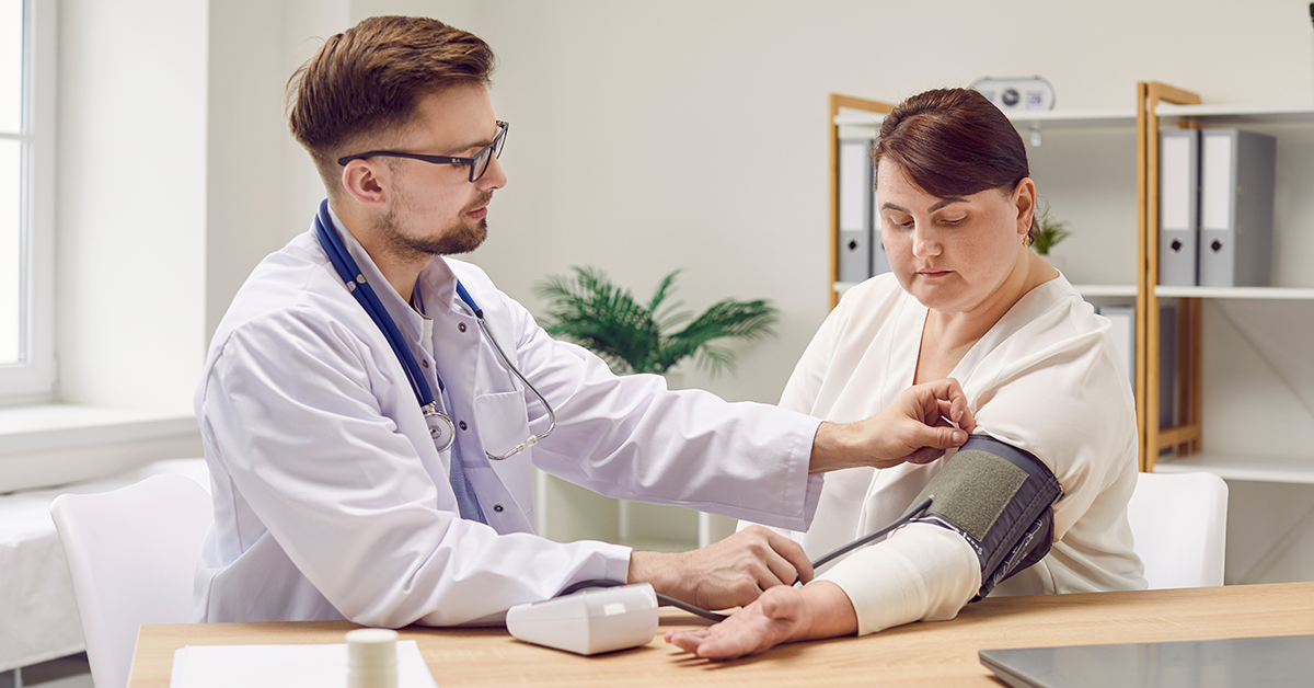 Male doctor checks blood pressure of female patient