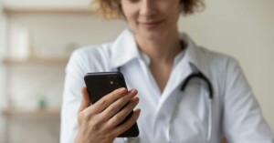 A GP uses her mobile phone to contact the family violence secondary consult service