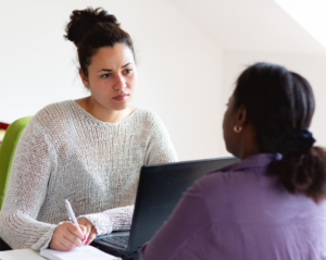 A primary health care practitioner speaks with a patient and takes notes