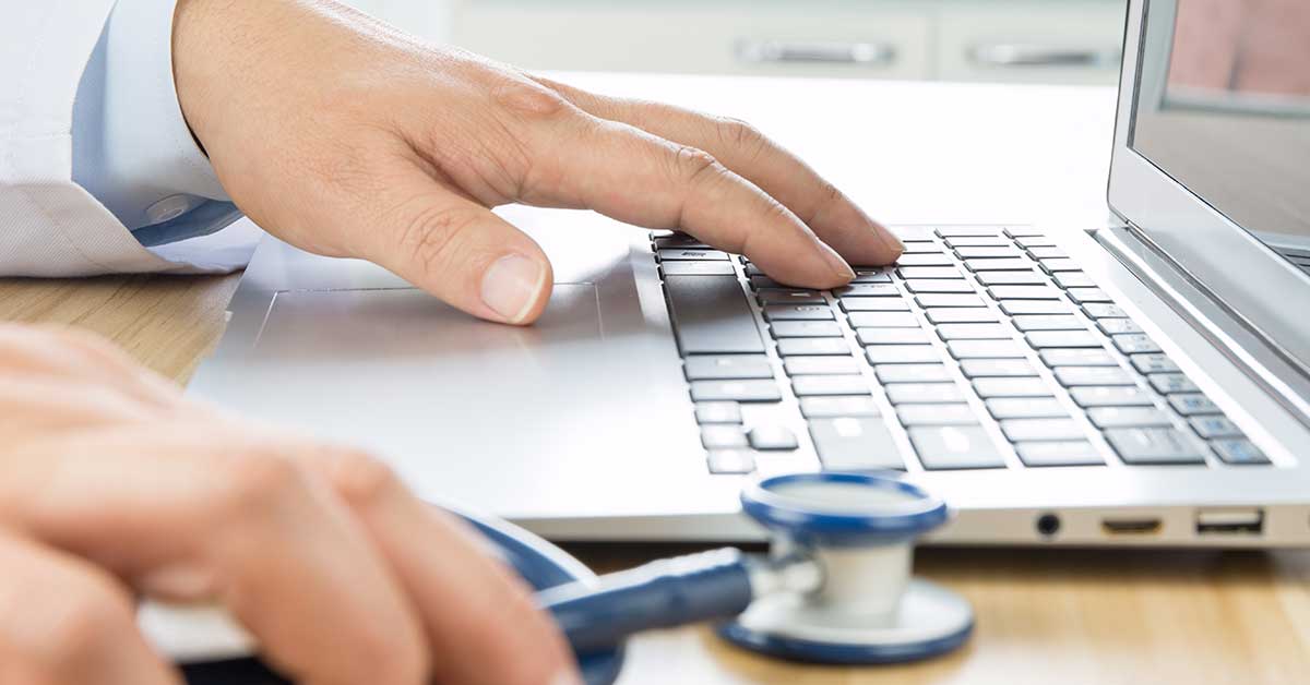 General practitioner works on his laptop