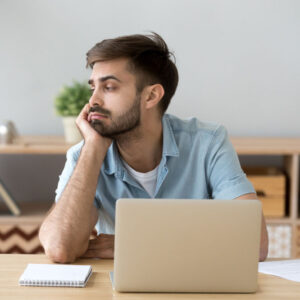 Male adult sits at his desk, distracted